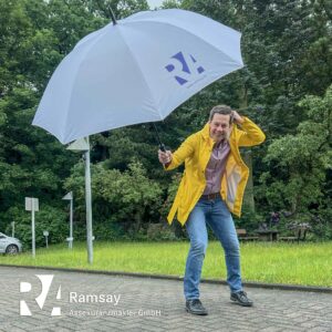 Olaf Marx, Mitarbeiter bei Ramsay Assekuranzmakler mit Regenschirm